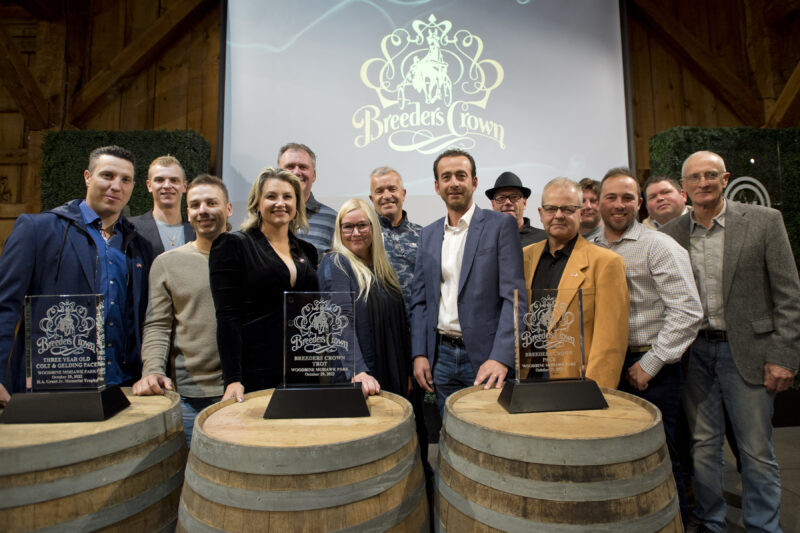 Group of people posing with Breeders Crown trophies.